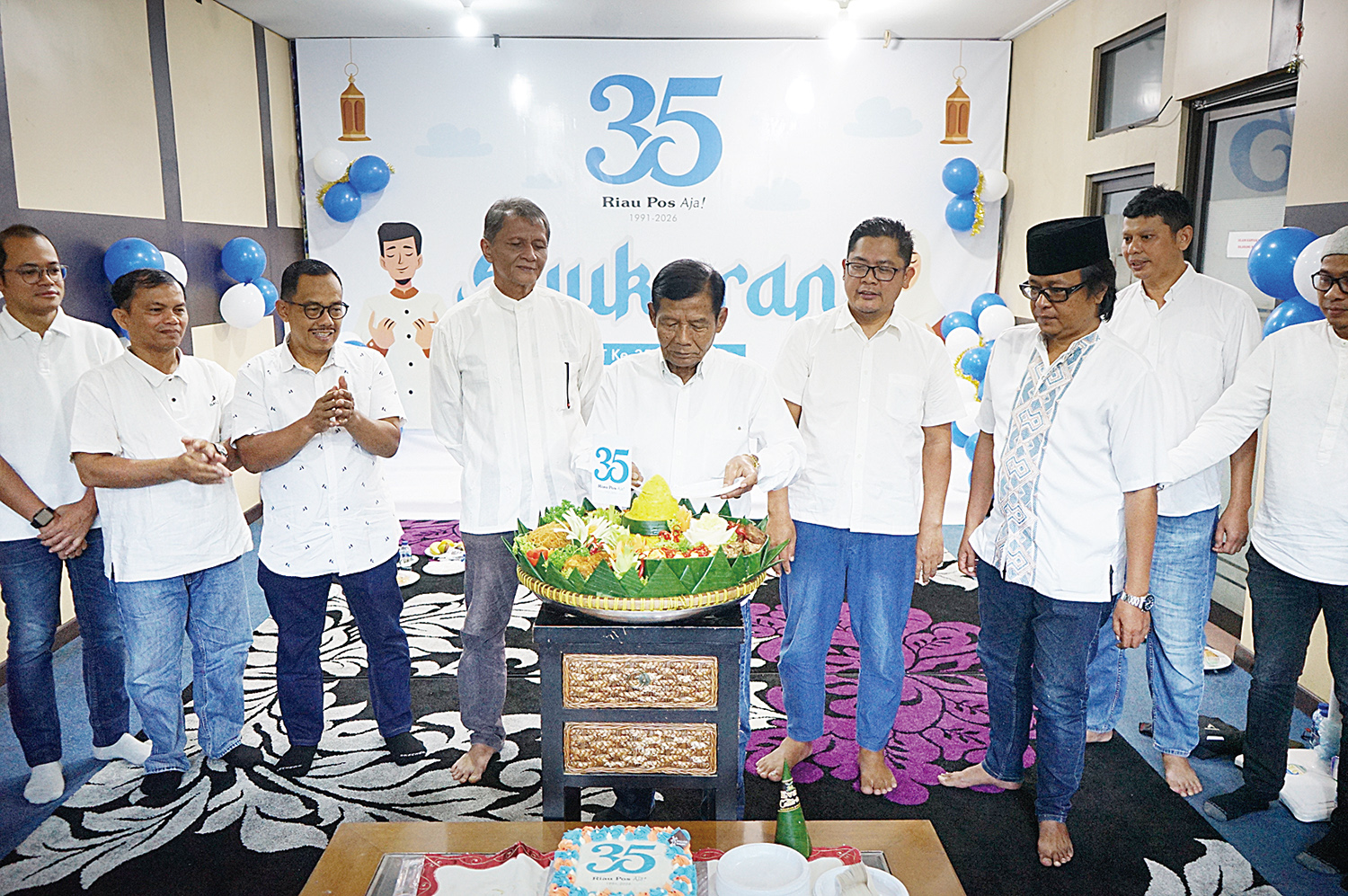 Wakil Komisaris Utama Riau Pos Amril Noor disaksikan Komisaris Raznizal Syukur, Direktur Utama Ahmad Dardiri, Direktur Firman Agus, Direktur Asmawi Ibrahim, serta jajaran memotong tumpeng saat syukuran HUT ke-35 Riau Pos di Gedung Riau Pos, Sabtu (17/1/20