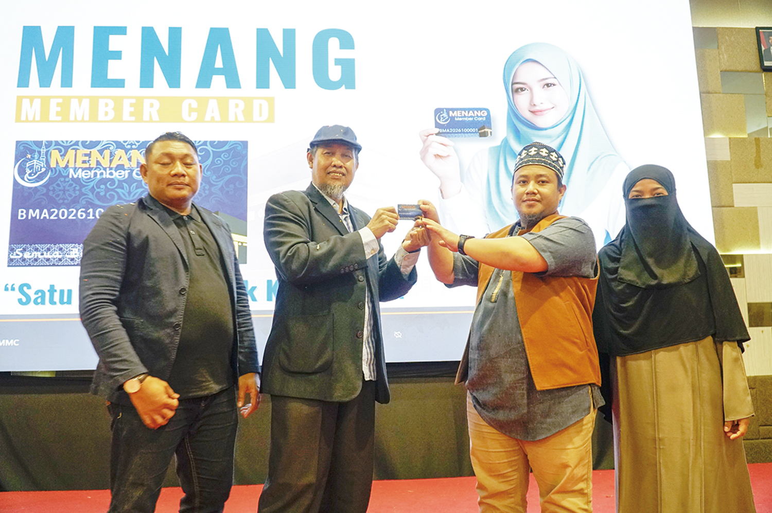 Direktur Pengembangan Bisnis Menang Tour & Travel Syamsul Bahri Samin (dua kiri) didampingi Direktur Operasional Ade Saputra (kiri) menyerahkan member card kepada Direktur Utama Rahmad Rivaldi.