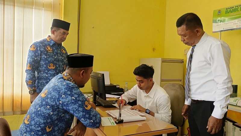 Bupati Inhu, Ade Agus Hartanto S.Sos MSI didampingi Sekdakab Inhu, Zulfahmi Adrian AP MSI saat membuka tabungan melalui kasir BPR disaksikan Direktur Umum BPR Indra Arta, Yuli Andesra SE MM.