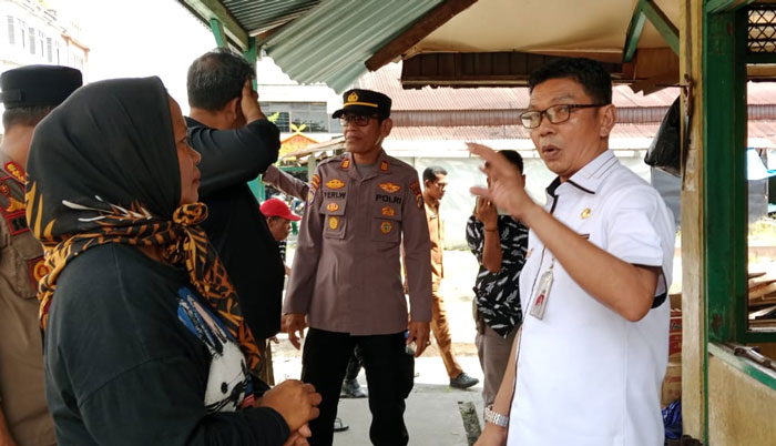 Ketua Tim Pembongkaran Pasar Bawah Teluk Kuantan H Fahdiansyah saat menjelaskan pada pedagang merangkap pemilik kios di sela-sela pembongkaran, Selasa (20/1/2026).