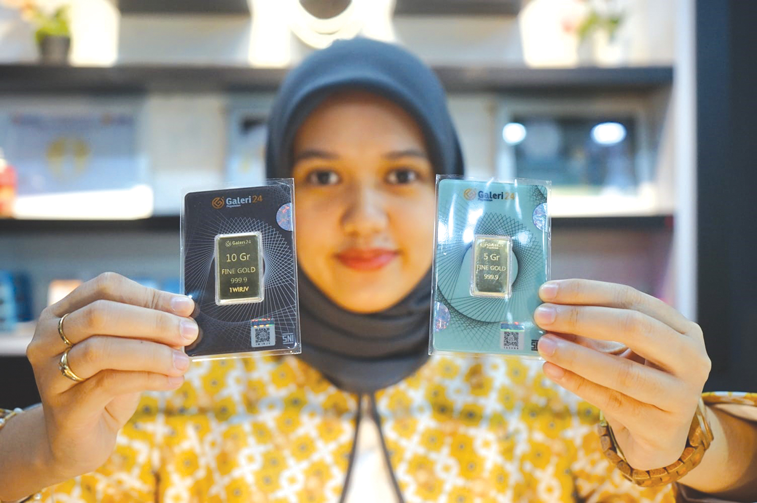 Pegawai Galeri 24, Pingkan, memperlihatkan emas batangan yang dijual di Galeri 24 Jalan Sudirman Pekanbaru, baru-baru ini. Harga emas Antam naik mencapai Rp2.705.000 per gram, Selasa (20/1/2026).