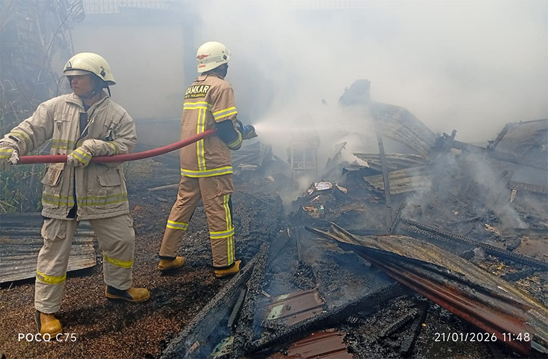 Petugas Damkar melakukan pemadaman api di gudang penyimpanan barang rumah tangga di Jalan Teuku Umar, Kecamatan Lima Puluh, Kota Pekanbaru, Rabu (21/1/2026).