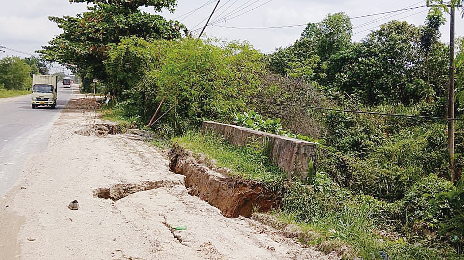 Bahu Jalan Siak II mengalami amblas akibat tergerus aliran Sungai Umban, Selasa (20/1/2026). Pengendara harus berhati-hati saat melintas di kawasan ini.