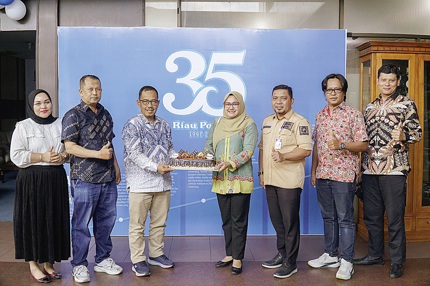 Direktur Riau Pos Asmawi Ibrahim menerima potongan tumpeng yang diserahkan langsung oleh Direktur Rs Syafira dr Rina Alfiani turut serta Direktur Riau Pos Firman Agus (Dua Kanan) saat Rs Syafira berkunjung ke Riau Pos, sempena Hut 35 tahun Riau Pos, Pekan
