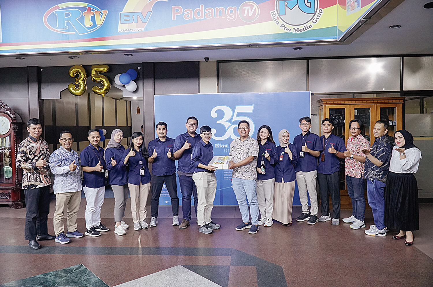 Direktur Utama Riau Pos Ahmad Dardiri menerima kue tar Hut Ke-35 Riau Pos yang diserahkan langsung oleh Corporate Communication RS Awal Bros Group Sari Rezki Antika saat Rs Awal Bros berkunjung ke Riau Pos, sempena Hut 35 tahun Riau Pos, Pekanbaru, Senin