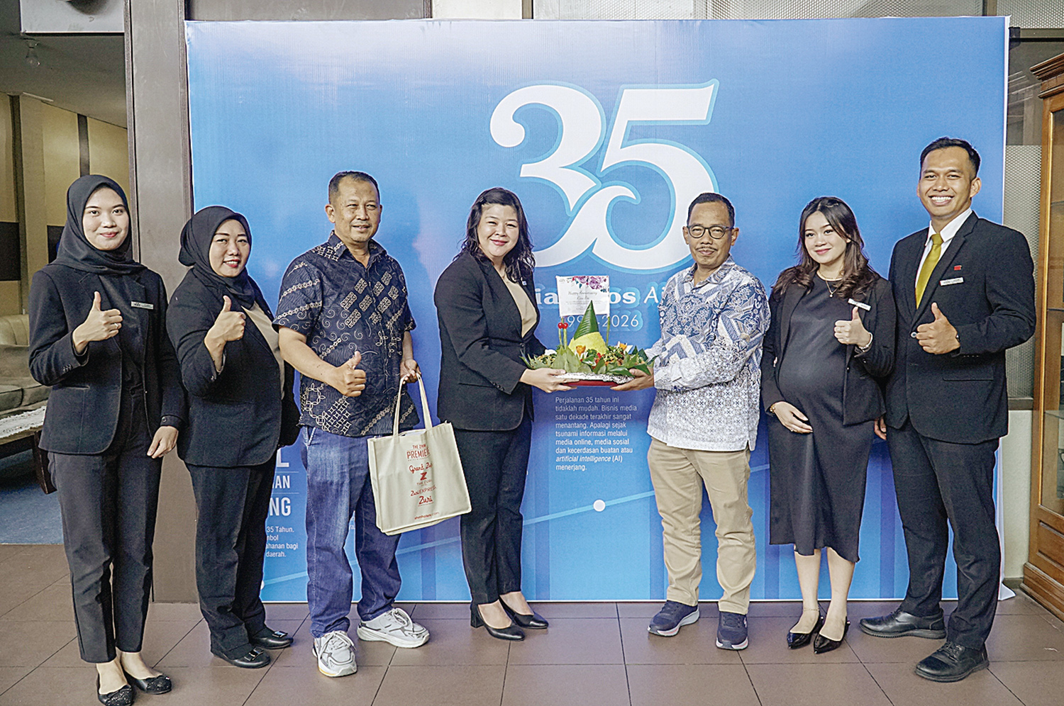 Direktur Riau Pos Asmawi Ibrahim menerima potongan tumpeng yang diserahkan langsung oleh GM  Premiere Hotel Pekanbaru Wismi huang (Empat Kiri) saat berkunjung ke Riau Pos, sempena Hut 35 tahun Riau Pos, Pekanbaru, Senin (19/1/2026)