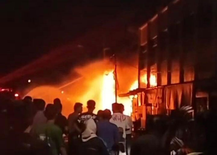 Warga membantu memadamkan api yang membakar kedai pancing di sekitar Turap Singapura Kota Siak, Rabu (21/1/2026).