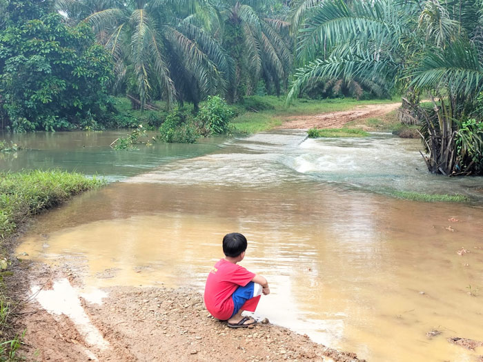 Seorang balita sedang bermain air saat banjir merendam Jembatan Beton di ruas jalan penghubung antara Dusun Kubu Manggis menuju DU SKPC Rambah Hilir, belum lama ini.