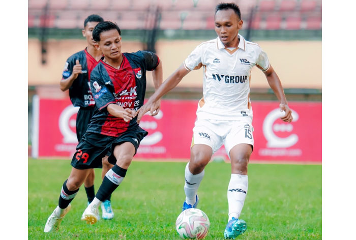 Pemain WGroup Fauzan (kanan) berebut bola dengan pemain Kampar Junior FC Rien Fernandes dalam pertandingan RS Awal Bros Liga 4 Zona Riau 2025/2026 di Stadion Utama Riau, Rabu (21/1/2026).