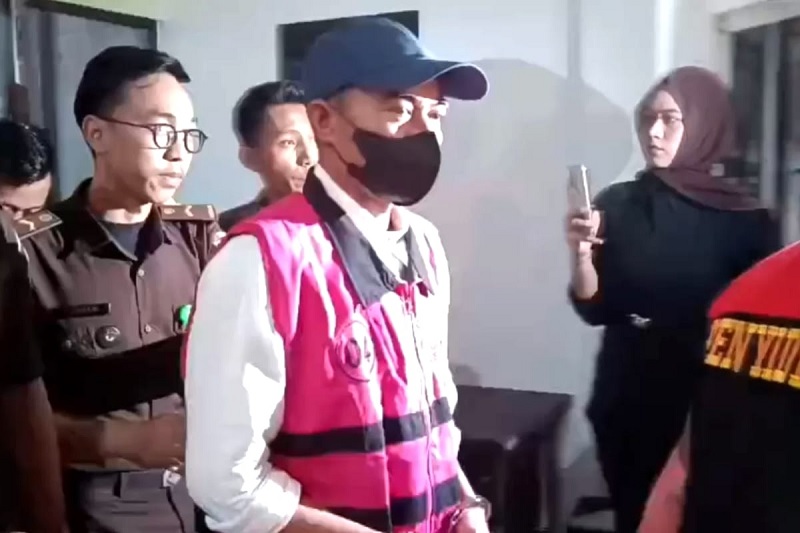Tim Pidsus Kejari Pelalawan menggiring RM, tersangka baru kasus korupsi dugaan penyelewengan pupuk bersubsidi dari Kantor Kejari Pelalawan menuju mobil tahanan, Rabu (21/1/2026) malam.
