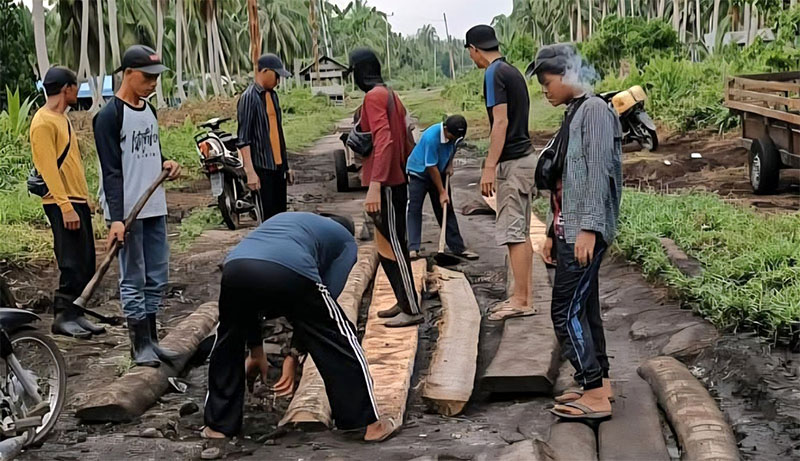 Salah satu ruas jalan di Pulau Rangsang Kepulauan Meranti yang kondisinya rusak parah sedang diperbaiki warga.