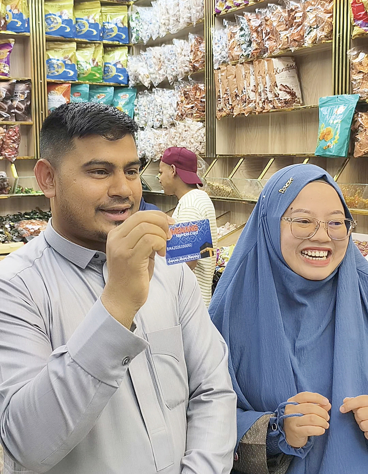 Pemilik toko oleh-oleh di Madinah Mu&shy;hammad Mostafis didampingi Manager Pengembangan Bisnis Menang Tour & Travel Chantika Erviviany menunjukkan menang member card.