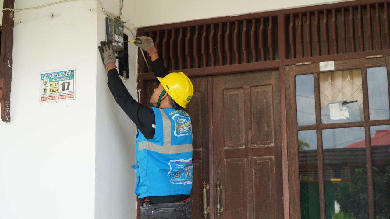 Petugas PLN saat melakukan penggan&shy;tian miniature circuit breaker (MCB) pada kWh meter pelanggan yang melakukan tambah daya listrik.