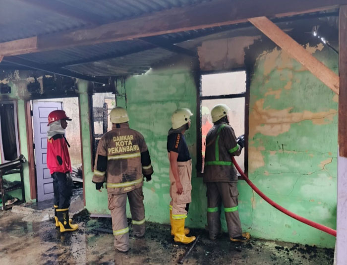 Petugas tengah melakukan upaya pemadaman yang melanda sebuah rumah di Jalan Kencana Sari Gang Kencana Sari, Kelurahan Umban Sari, Kecamatan Rumbai, Kota Pekanbaru, Ahad (25/1/2026) pagi.