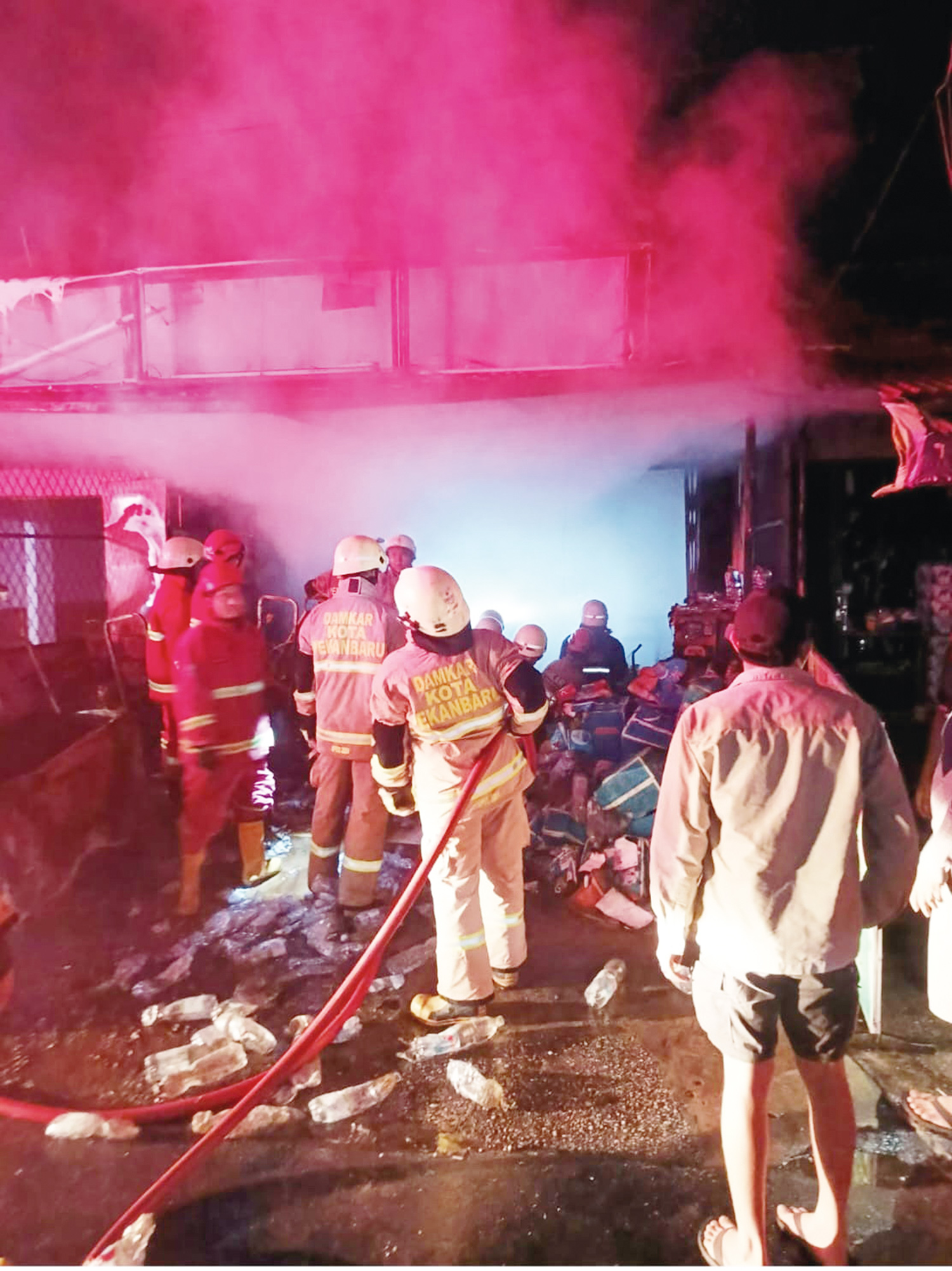 Petugas Pemadam Kebakaran saat mengevakuasi jenazah korban kebakaran kios barang harian di Jalan Tengku Bey RT 001 RW 003, Kelurahan Simpang Tiga, Kecamatan