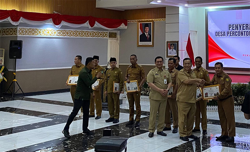Plt Gubri SF Hariyanto menyerahkan penghargaan kepada desa percontohan antikorupsi 2025 di gedung daerah Riau, Senin (26/1/2026).
