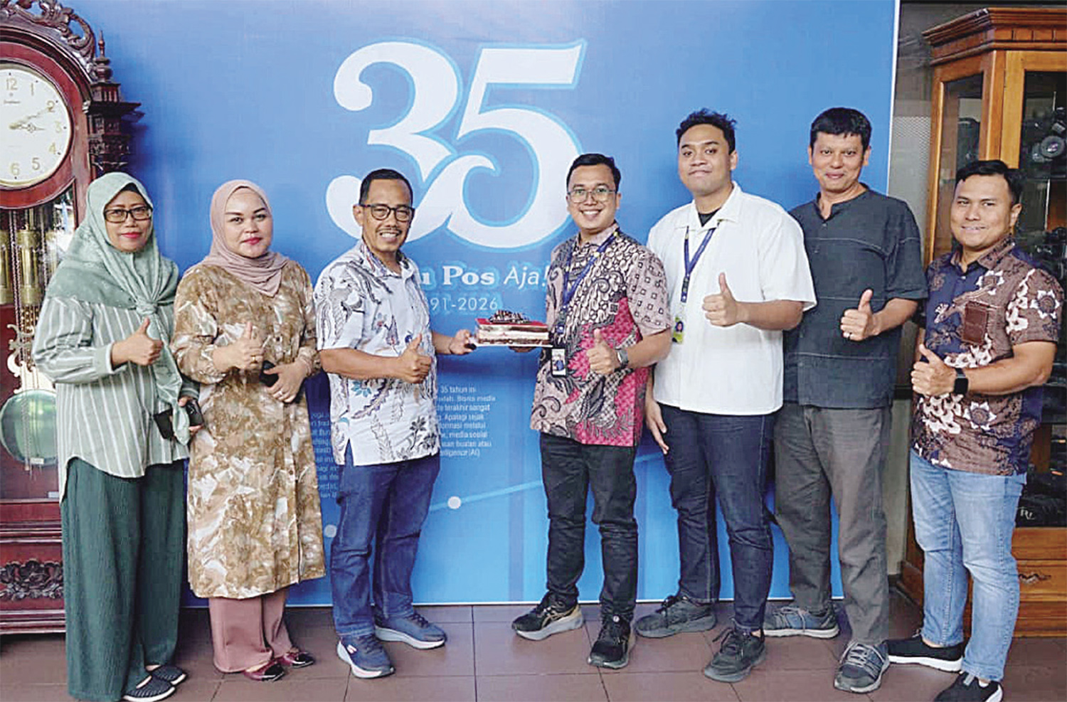 Assistent Digital Marketing & Creative Manager Living World Noval Akbar (empat kanan) dan Property Management Trainee Living World Faishal Dzamar Rosul (tiga kanan) menyerahkan kue ulang tahun kepada Direktur Riau Pos Asmawi Ibrahim (tiga kiri) didamp