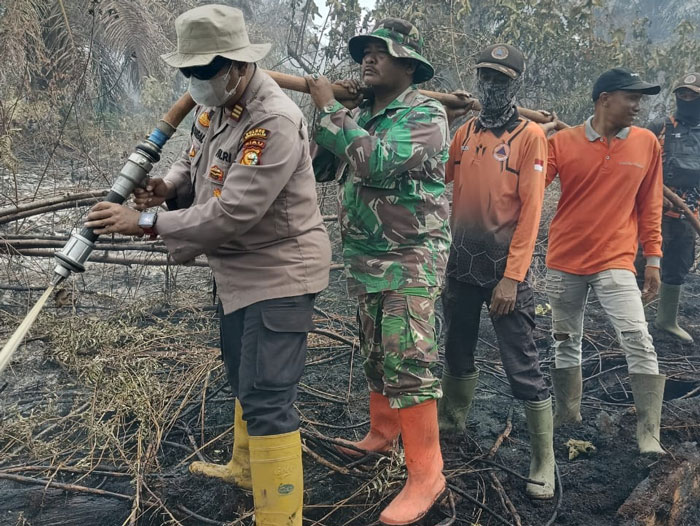 Kapolsek Rupat AKP Faisal memimpin pendinginan api Karhutla di Jalan Sukajadi RT09/RW05 Dusun Teluk Kumbang Desa Sukoharjo Mesim Kecamatan Rupat, Bengkalis, Senin (26/1/2026) pagi.