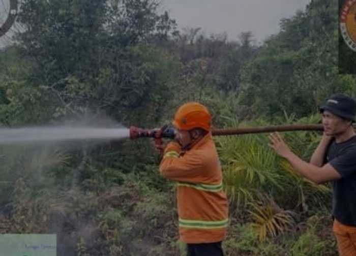 Tim Satgas BPBD Kabupaten Kampar memadankan api yang membakar lahan di Desa Penyesawan Rumbio, Kecamatan Kampar Timur, Kabupaten Kampar, Senin (26/1/2026).