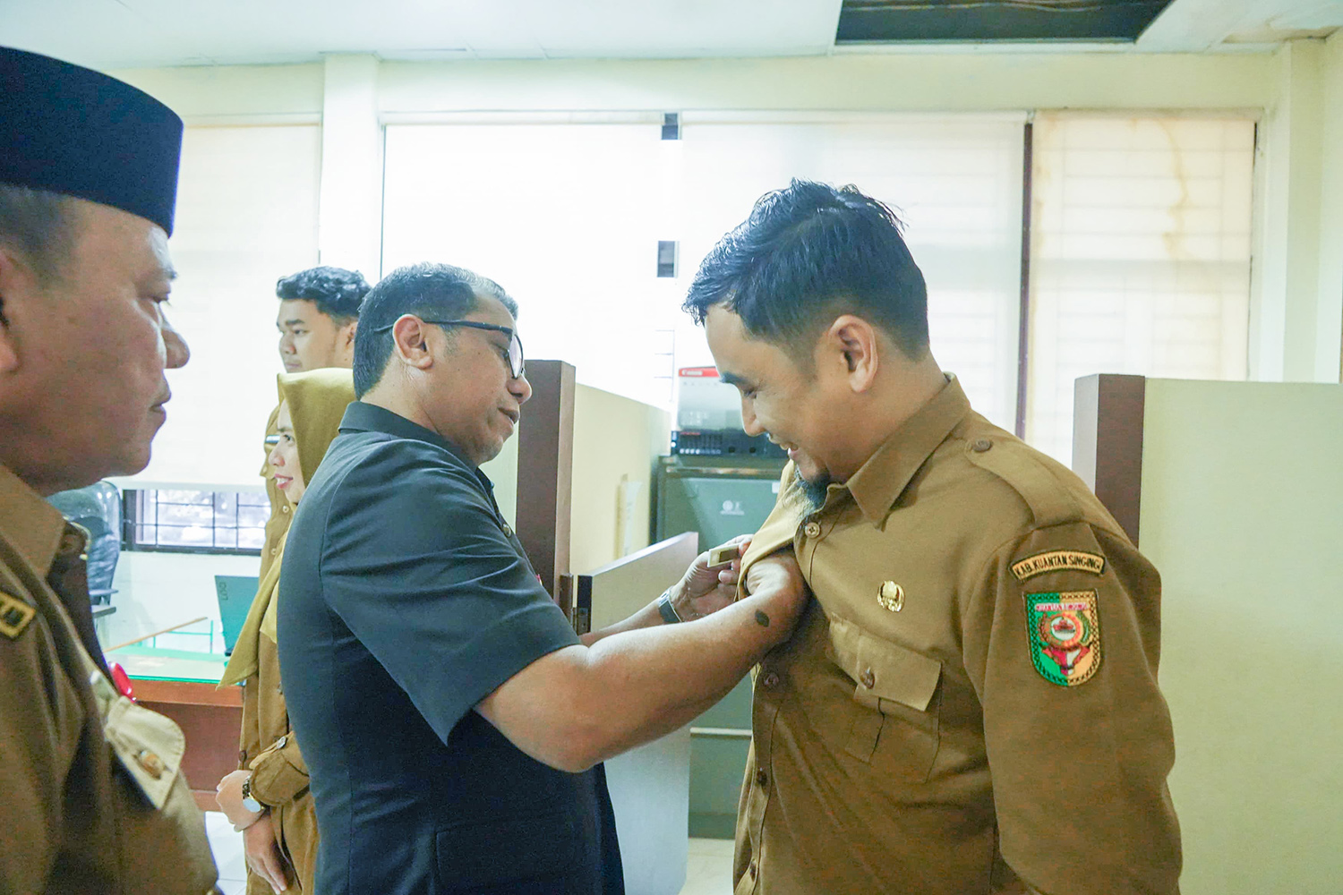 Sekdakab Kuansing Zulkarnain ST MSi memeriksa name tag salah satu pegawai saat sidak ke Dinas Kominfos Kuansing, Senin (26/1/2026).