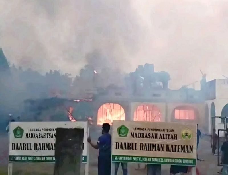 Api tampak menjalar dan asap tebal membumbung tinggi di asrama Pondok Pesantren Daarul Rahman yang berada di Jalan Santri, Desa Air Tawar, Kecamatan Kateman, Inhil, Senin (26/1/2026).