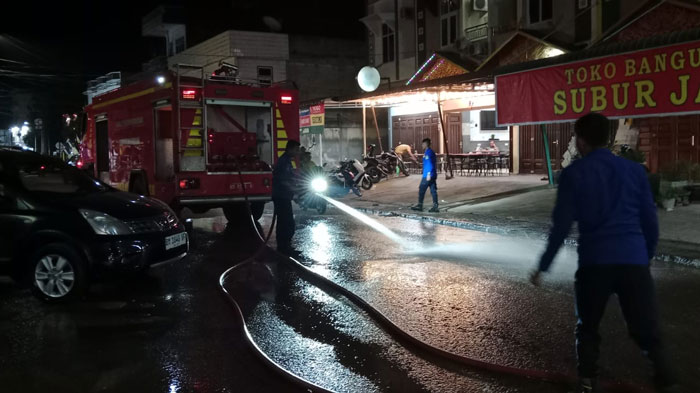 Satpol PP-PKP Kuansing, melakukan penyiraman ceceran tanah timbun di Jalan Sudirman Teluk Kuantan-eks kios Pasar Bawah Teluk Kuantan, Selasa (27/1/2026).