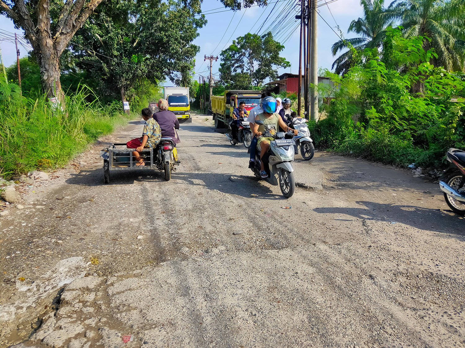 Pengendara melintas di Jalan Umban Sari, Kecamatan Rumbai, Pekanbaru yang mengalami kerusakan. Foto diambil belum lama ini.