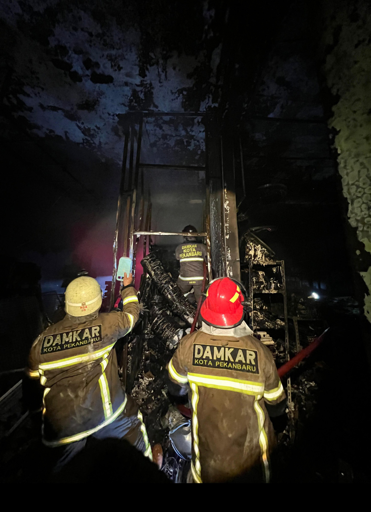 Petugas damkar melakukan upaya pemadaman api yang membakar ruko empat pintu di Jalan Jenderal Sudirman, Kelurahan Pesisir, Kecamatan Limapuluh, Pekanbaru, Senin (26/1/2026).