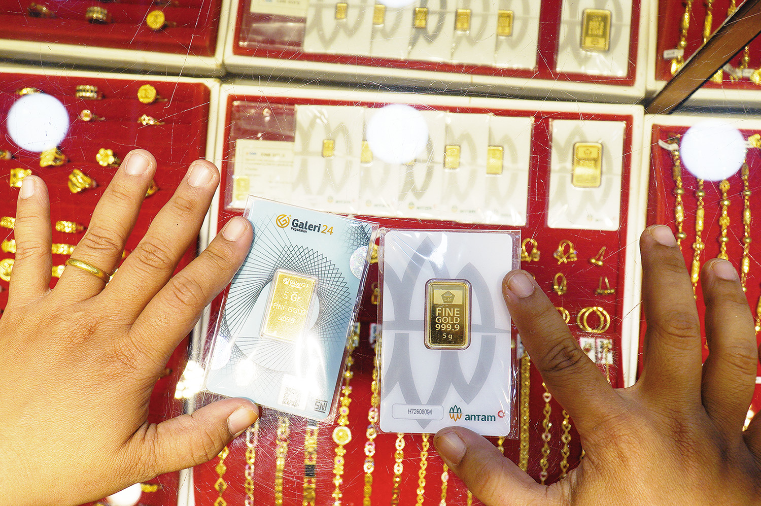 Pembeli memilih  emas mulia seberat 5 gram yang dikeluarkan oleh Galeri 24 Pegadaian (Kiri) dan Antam (Kanan) di Toko Emas Asia STC, Pekanbaru, Senin (26/1/2026).
