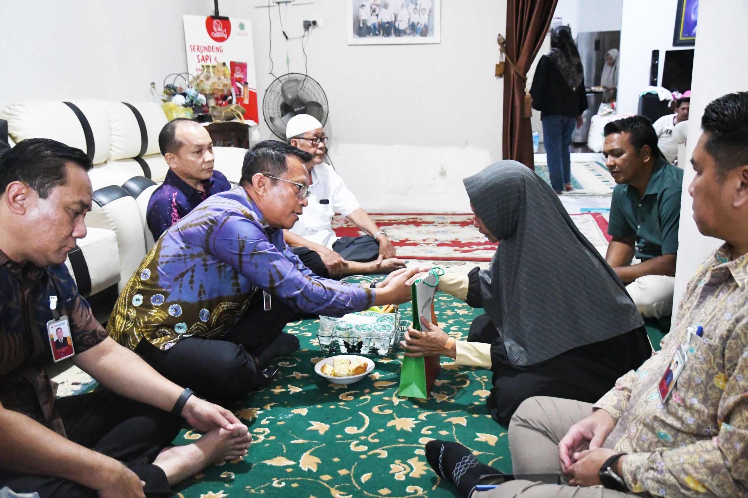 Jajaran direksi dan manajemen BRK Syariah mengunjungi rumah duka keluarga almarhumah Siti Hajar Harahap dan menyerahkan santunan yang diterima langsung oleh ibu kandung almarhumah.