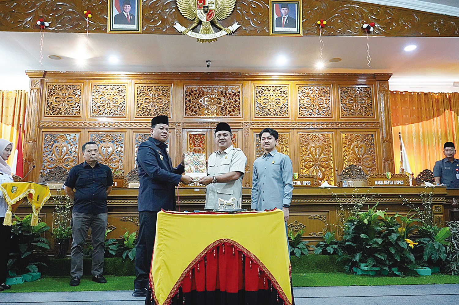 Ketua DPRD Kuansing H Juprizal SE MSi (dua kanan) didampingi Wakil Ketua I DPRD Satria Mandala Putra (kanan) menyerahkan Perda MHA kepada Bupati Kuansing Dr H Suhardiman Amby MM (kiri) usai disahkan.