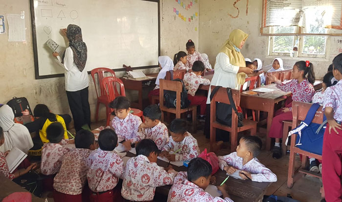 Anak-anak rombongan belajar dibagi dua dalam satu ruang kelas demi menimba ilmu ditengah keterbatasan sarana dan prasarana, Kamis (29/1/2026).