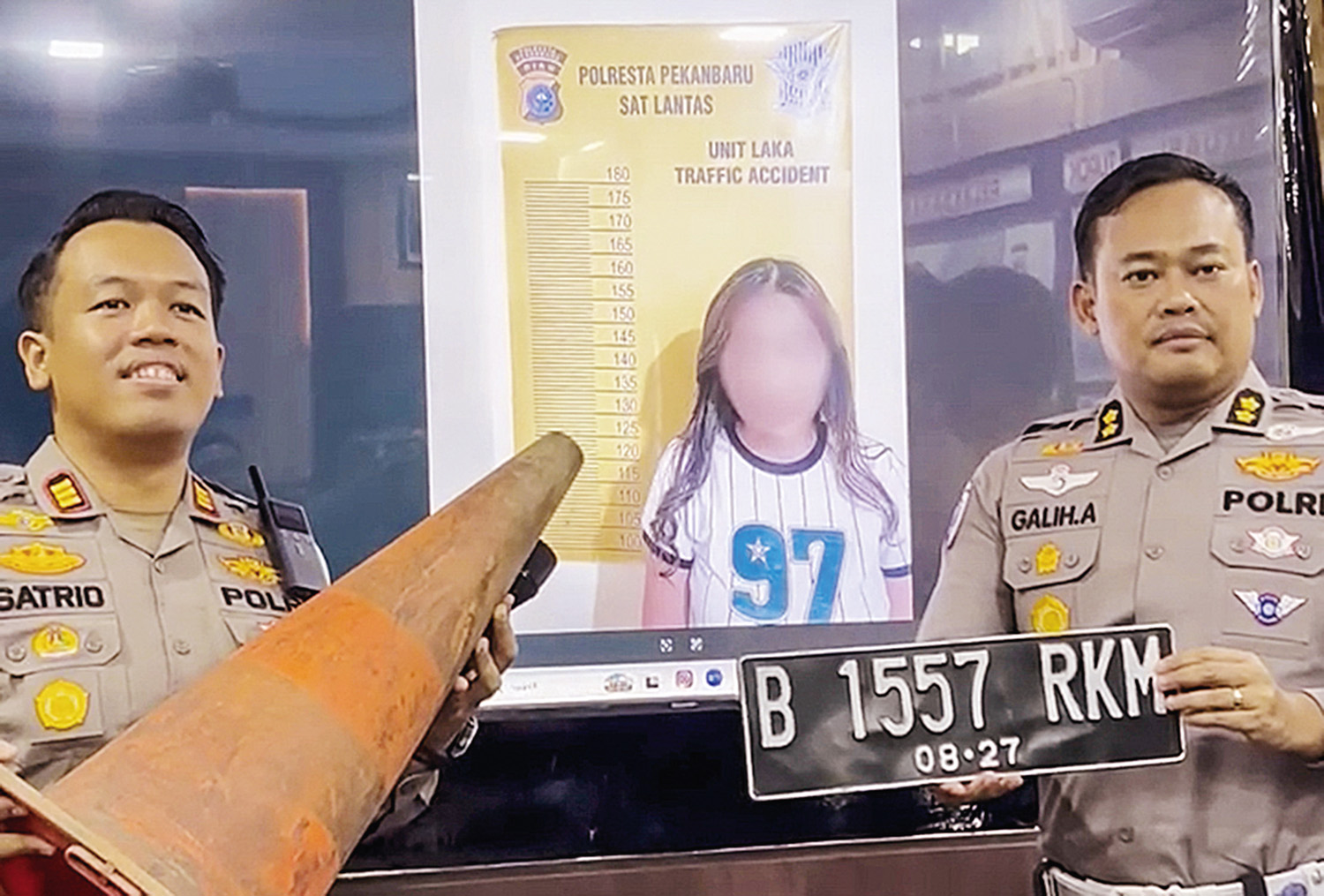 Kasubdit Gakkum Ditlantas Polda Riau AKBP Galih Apria (kanan) dan  Kasatlantas Polresta Pekanbaru Kompol Satrio BW Wicaksana (kiri) memperlihatkan barang bukti berupa pelat nomor kendaraan.