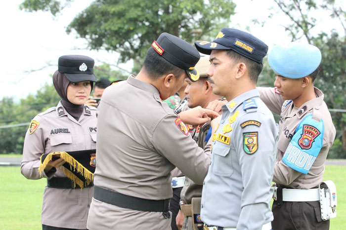 Waka Polres Kuansing Kompol Nardy Masry memasang pita personel operasi Keselamatan Lancang Kuning 2026, Senin (2/2/2026) di Mapolres Kuansing.