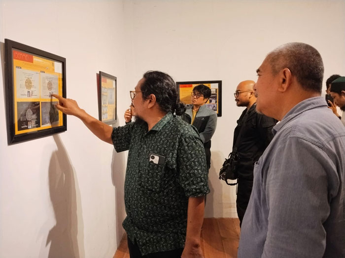 Elmustian Rahman melihat Junaidi Syam yang menunjuk salah satu imej yang diidentifikasi pada pameran IDENTIC 4 di Galeri Hang Nadim (GHN), Senin (2/2/2026).