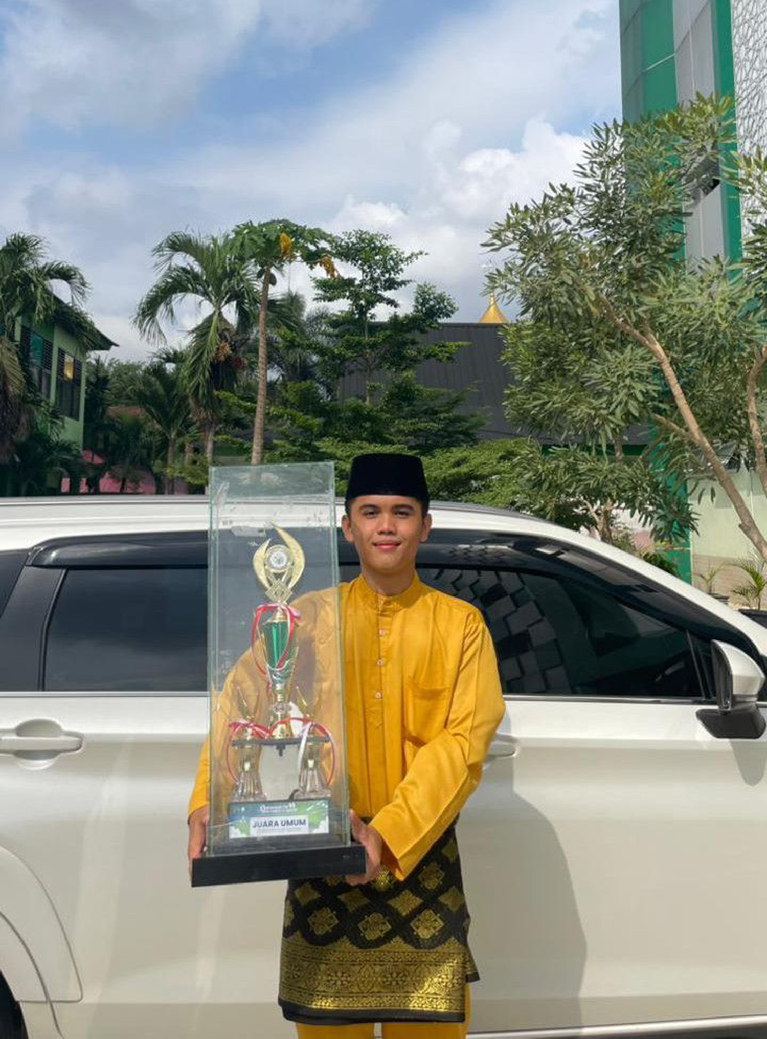 Muhammad Gibran Hakim memamerkan piala juara umum dalam ajang Qotrunnada Fair 6 tingkat Provinsi Riau, belum lama ini.