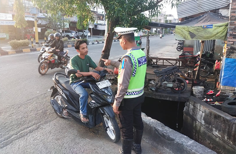 Personel Satlantas Polres Dumai saat memberikan edukasi kepada pengendara sepeda motor.
