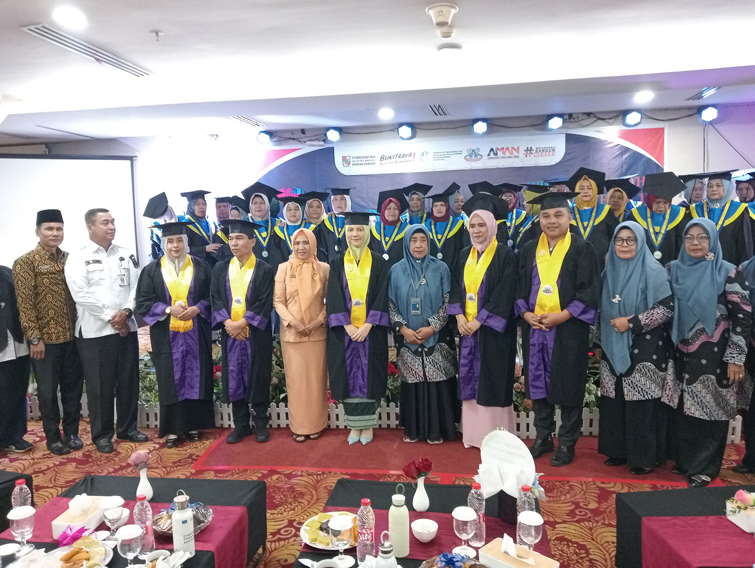 Ketua TP PKK Pekanbaru Sulastri Agung (tengah) foto bersama para wisudawati lansia yang mengikuti wisuda lansia tangguh Berkah Bersama Kecamatan Bukit Raya, Rabu (4/2/2026).
