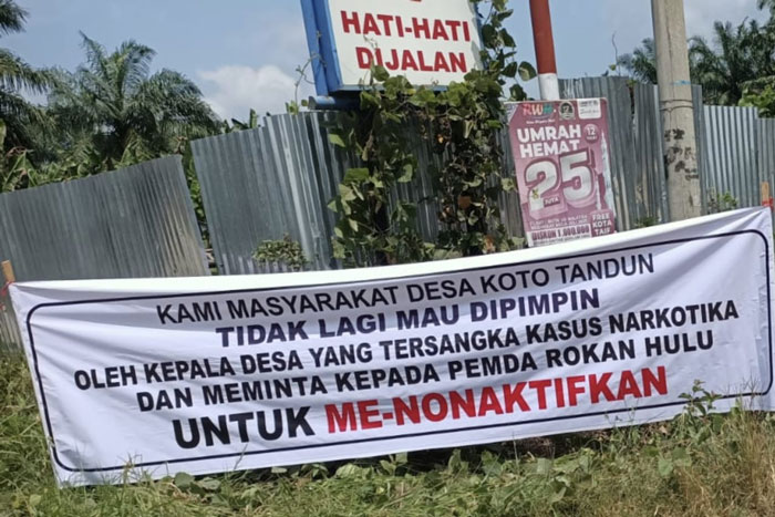 Aksi demo warga Desa Koto Tandun, Kecamatan Tandun memasang spanduk di ruas jalan, sebagai bentuk kekecewaan terhadap kasus hukum Kades Koto Tandun berinisial MTRS, Kamis (5/2/2026).