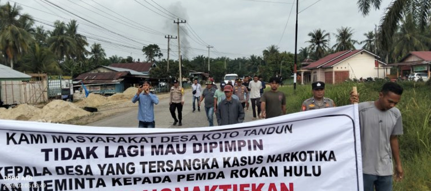 Puluhan warga melakukan long march membawa spanduk saat aksi demonstrasi di depan Kantor Desa Koto Tinggi, Kecamatan Tandun, Rohul, Kamis (5/2/2026).