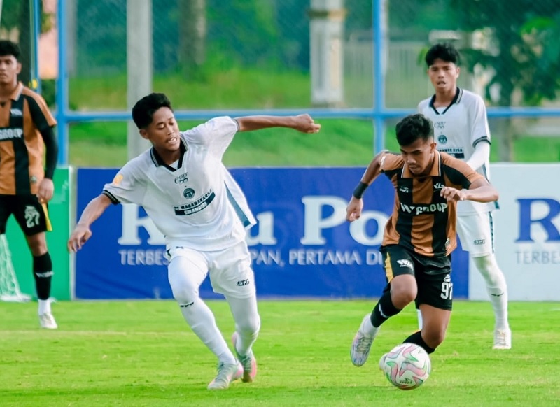 Gelandang Wahana FC Randi Saputra (kiri) dan pemain WGroup FC Adif Nor bersaing merebut bola dalam pertandingan Babak 4 Besar RS Awal Bros Liga 4 Riau 2025/2026 di Stadion Gelora Hang Tuah Pekanbaru.