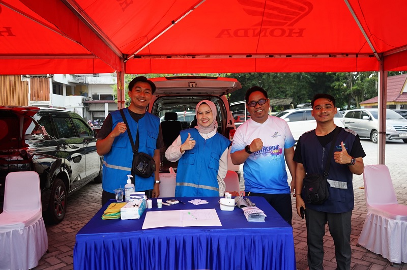 Kepala Divisi Sales dan Marketing Aulia Hospital, Endro Andika Putra (dua kanan) bersama tim saat di stan pada acara Riau Pos Fun Bike 2026 di MPP Pekanbaru, Jalan Sudirman, Ahad (8/2/2026).