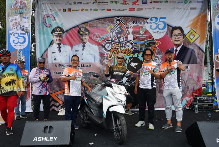 Dirut Riau Pos Ahmad Dardiri (kanan), Direktur Riau Pos Asmawi Ibrahim (4 kanan), Direktur Riau Pos Firman Agus (2 kanan) serahkan hadiah utama kepada pemenang Riau Pos Fun Bike di halaman MPP.