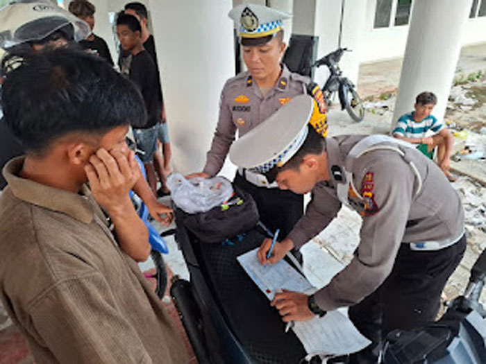 Petugas unit lantas Polsek Mandau melakukan penimbangan terhadap remaja yang akan melakukan balap liar di jalan lingkar kota duri, Ahad (8/2/2026) sore.