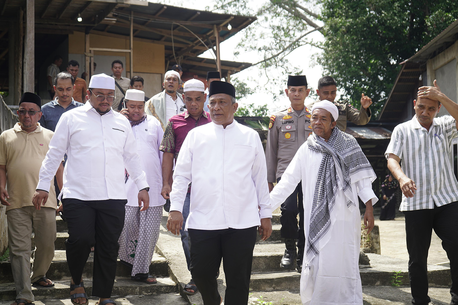 Bupati Rohul Anton ST MM berjalan beriring dengan tuan guru dan tokoh masyarakat saat menghadiri kegiatan penebaran bibit ikan di Lubuk Larangan Surau Suluk Al-Muqorrobah, Desa Kabun, Kecamatan Kabun,