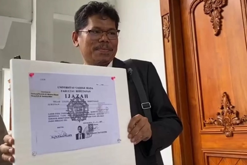 Pengamat kebijakan publik Bonatua Silalahi memamerkan salinan ijazah Presiden ke-7 RI Joko Widodo (Jokowi) di halaman Kantor Komisi Pemilihan Umum (KPU) RI, Jakarta, Senin (9/2/2026). )