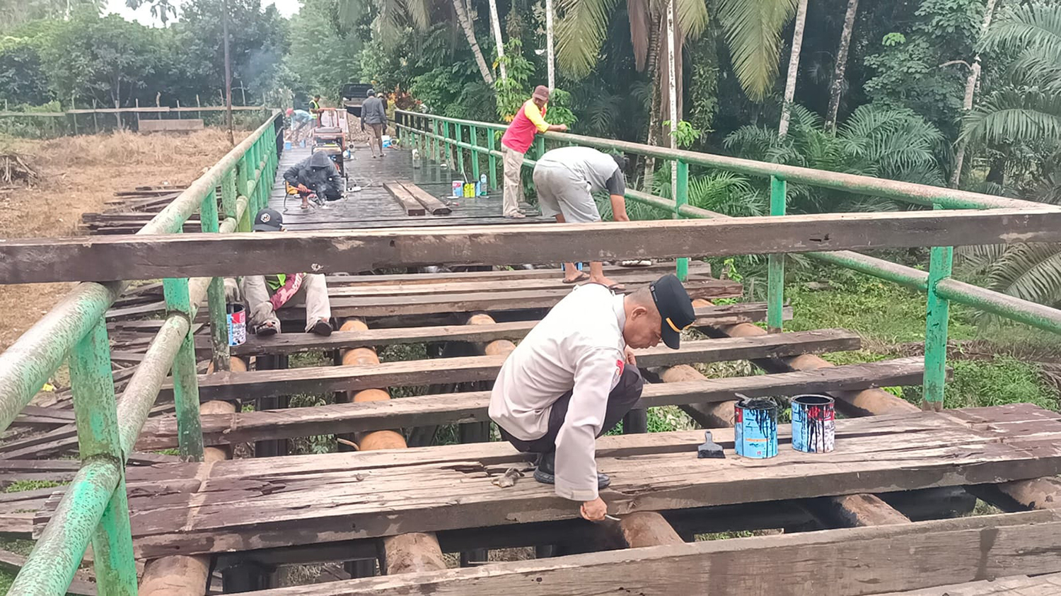 Personel Polres Kuansing dan masyarakat sedang mengerjakan pembangunan jembatan di Desa Sangau, Kecamatan Kuantan Mudik, Senin (9/2/2026).