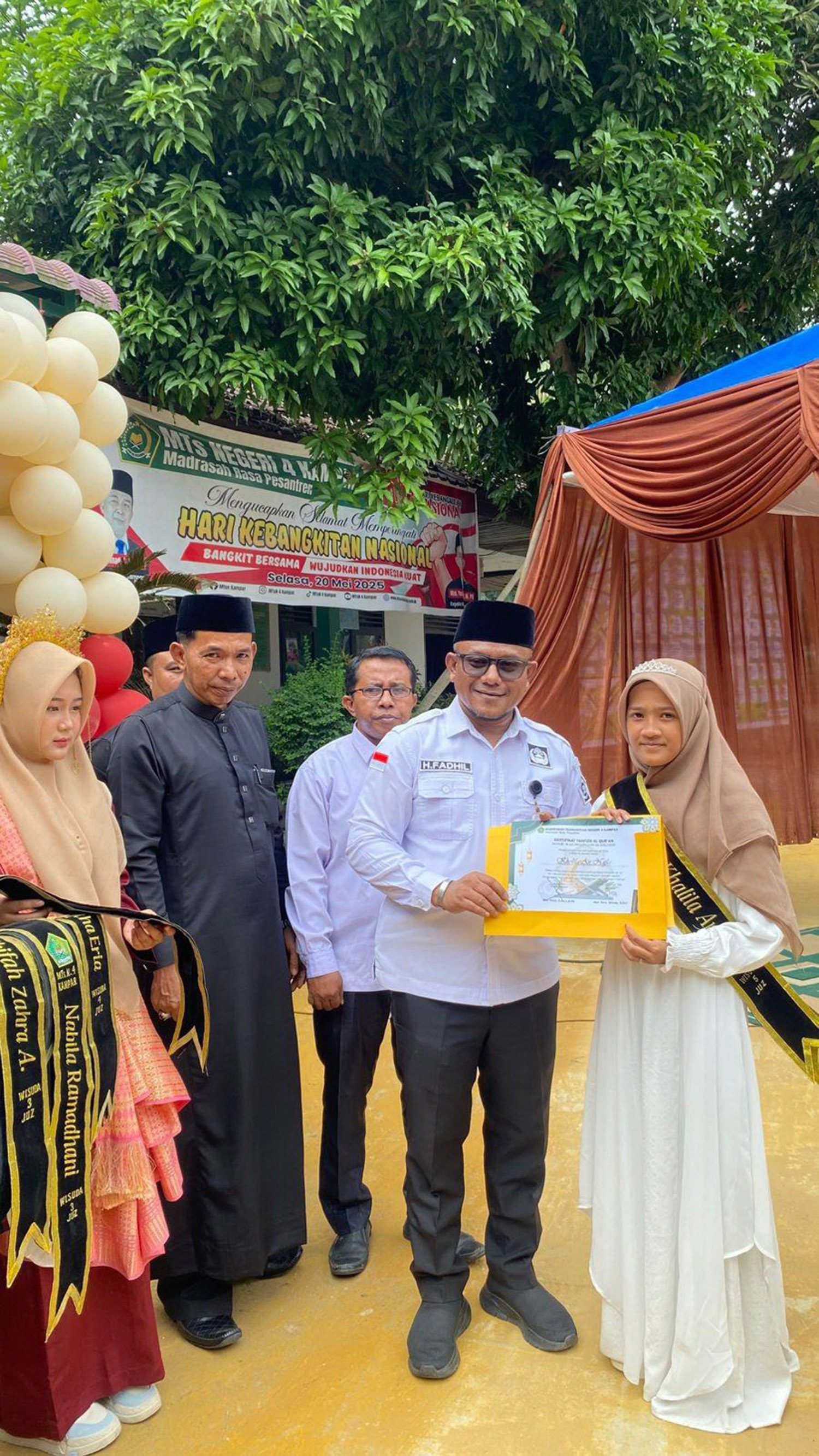 Kasubag Kemenag Kampar Muhammad Padli didampingi Kepala MTs Negeri 4 Kampar Mhd Yuras dan staf Kasi Zulhendri menyerahkan piagam wisuda tahfiz kepada perwakilan santriwati MTsN Kampar.