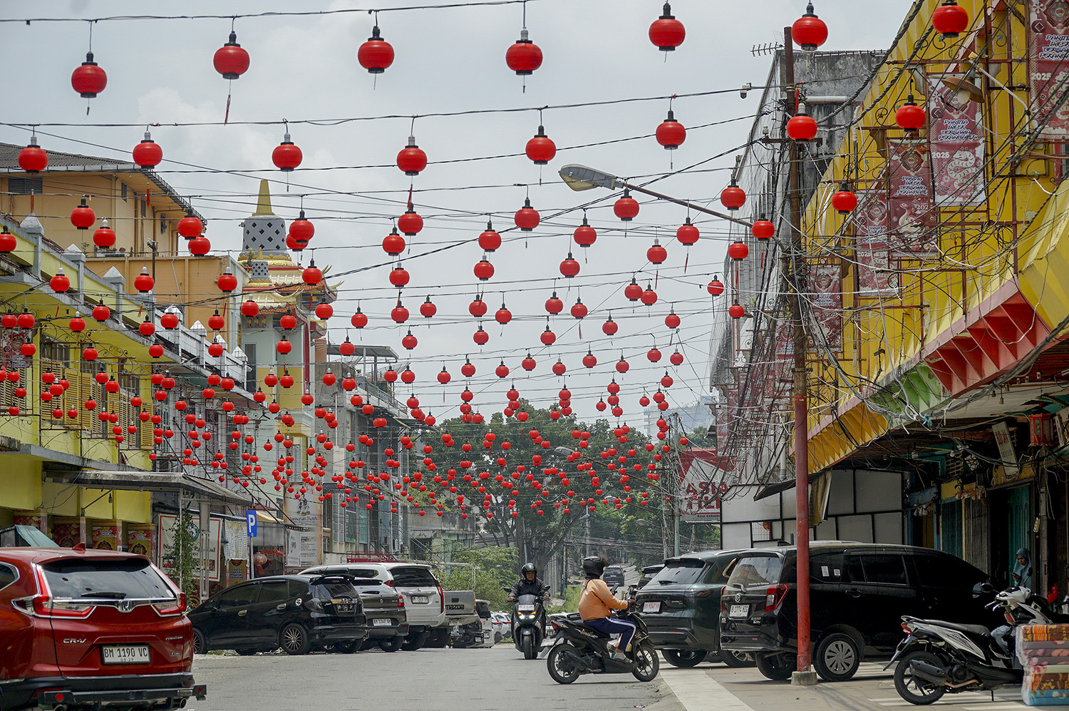 Pengendara melintas di Jalan Dr Leimena atau populer dengan sebutan Jalan Karet Chinatown Pekanbaru, dengan lampion merah jelang perayaan tahun baru Imlek 2026, Pekanbaru, Rabu (11/2/2026) ft: MHD AKHWAN/RIAUPOS