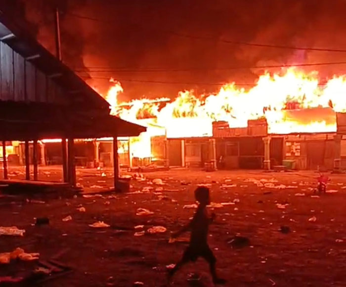 Seorang anak sedang berlari saat puluhan ruko dan rumah tempat tinggal di Pasar Rabu Desa Pekan Tebih, Kecamatan Kepenuhan Hulu, Rohul dilalap api, Rabu (11/2/2026) malam.
